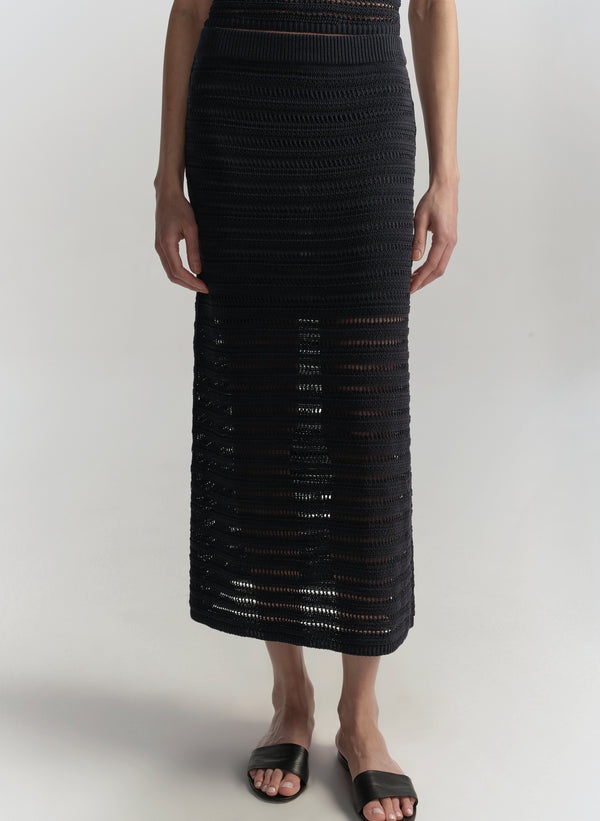 Person wearing a blue crochet skirt on a white background