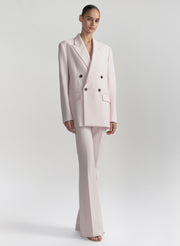 Woman wearing a light pink suit on a white background