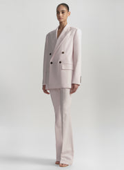 Woman wearing a light pink suit on a white background