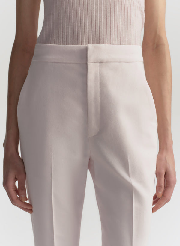 Light pink pants worn by a person on a white background