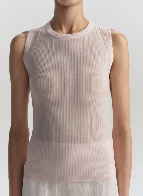 Light pink ribbed sleeveless top worn by a model on a light gray background