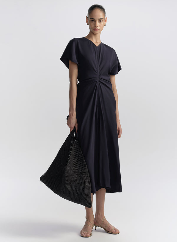 woman carrying black raffia tote