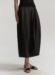 Person wearing a black skirt on a plain background
