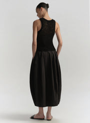 Woman wearing a black sleeveless top and skirt set on a white background