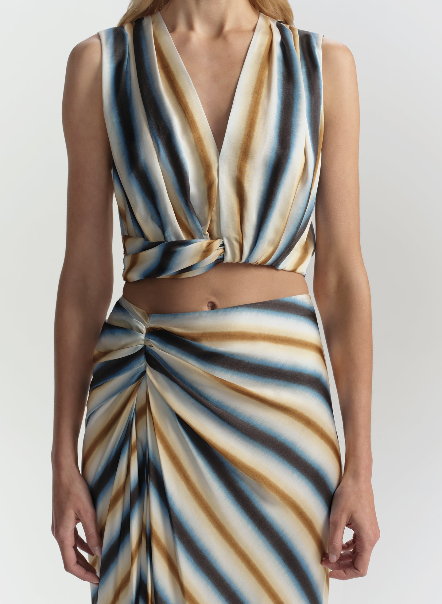 Woman wearing a striped outfit with a plain background