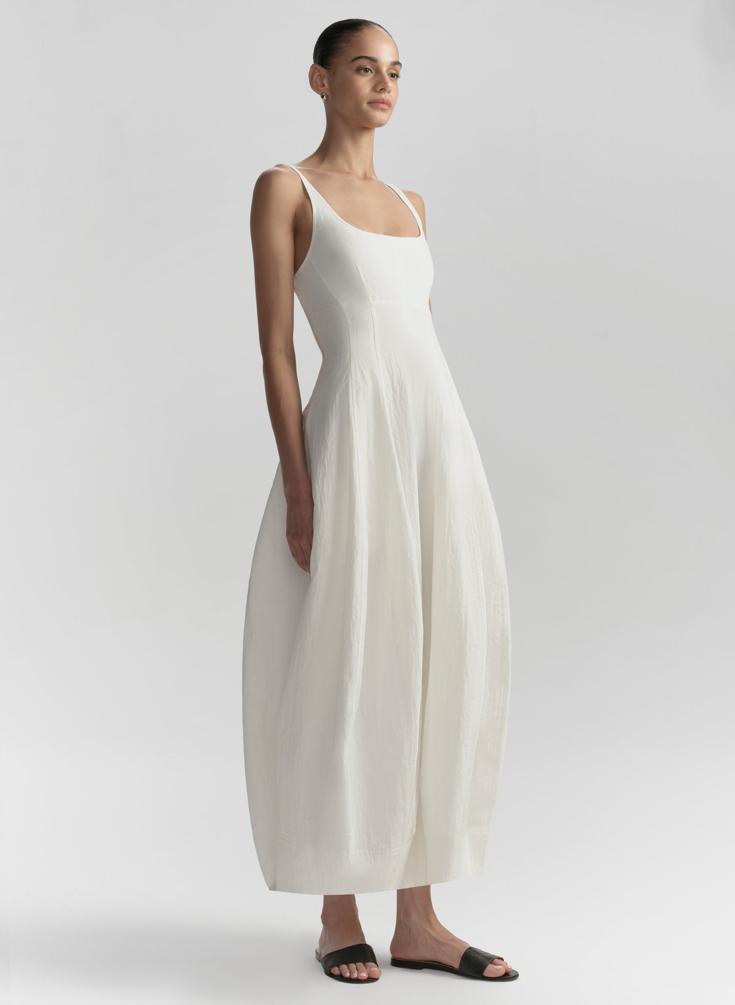 Woman wearing a white dress on a plain background