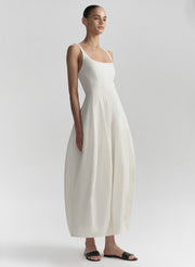 Woman wearing a white dress on a plain background