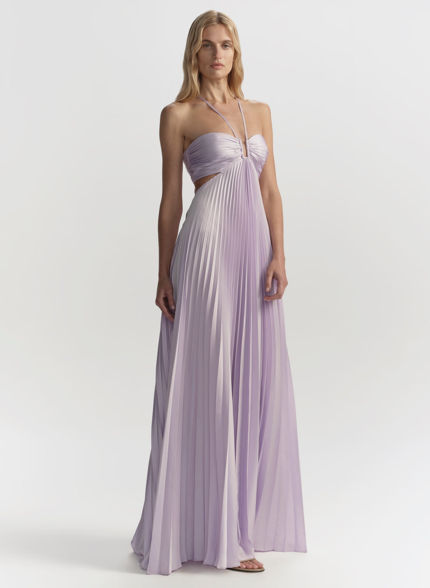Woman wearing a long, light purple gown on a white background