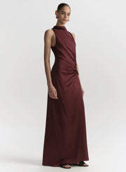 Woman wearing a long burgundy dress on a white background
