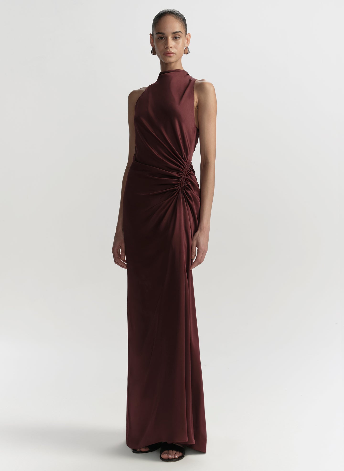 Woman wearing a burgundy evening gown on a white background