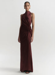 Woman wearing a burgundy evening gown on a white background