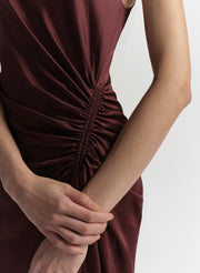 Purple dress with a ruched detail on a plain background