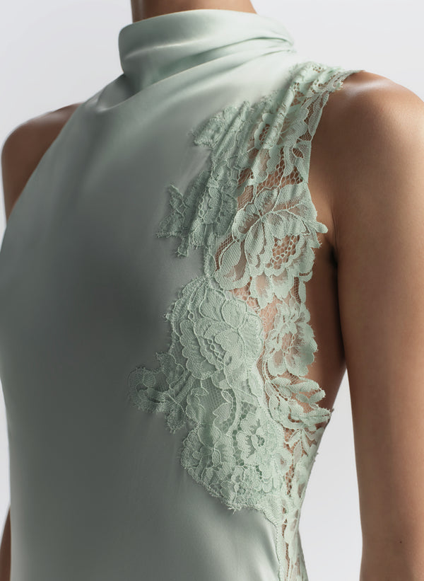 Light green sleeveless dress with lace detailing on a plain background