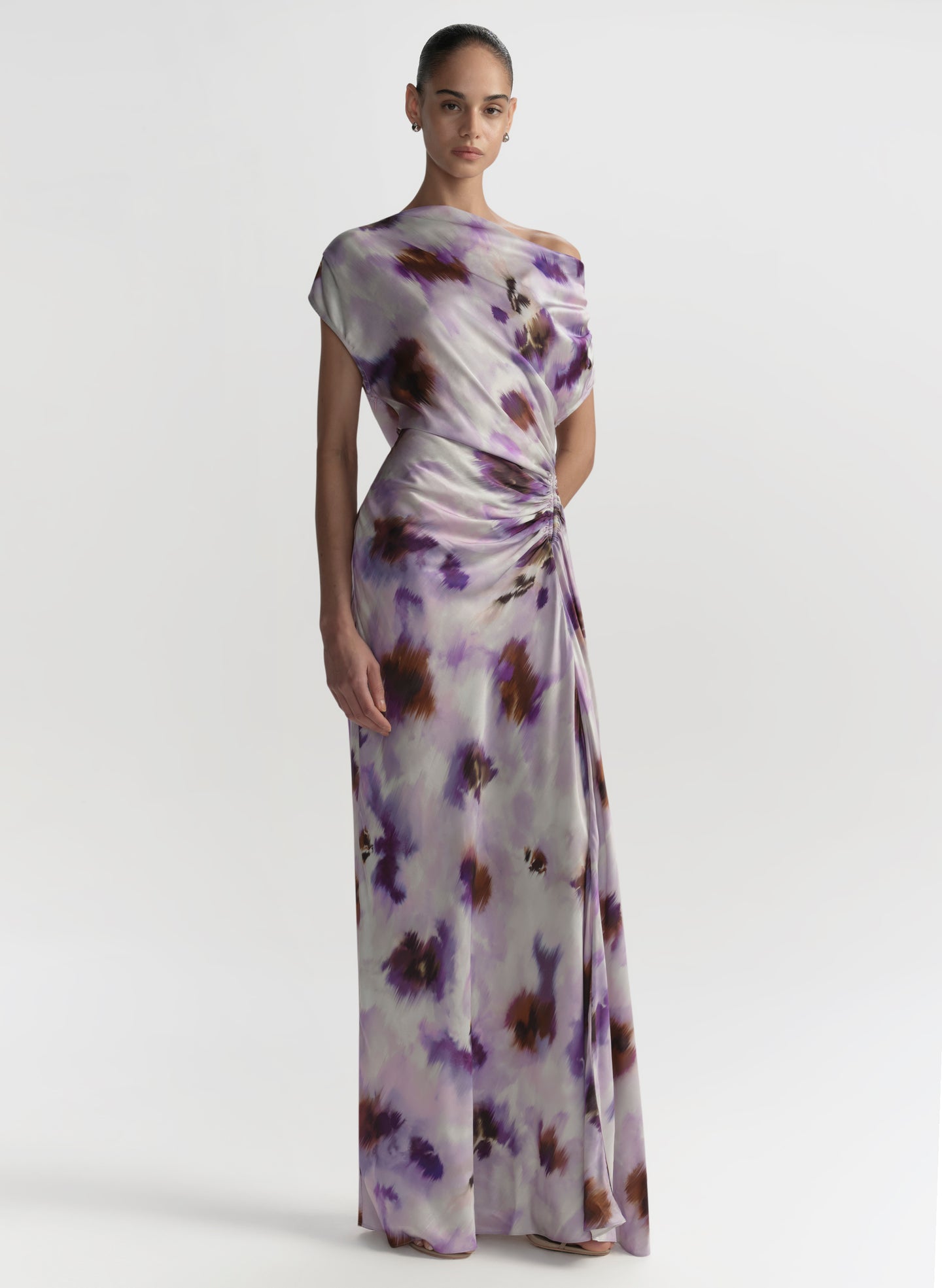 Woman wearing a long, floral-patterned dress on a white background