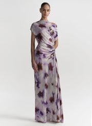 Woman wearing a long, floral-patterned dress on a white background