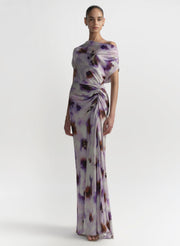 Woman wearing a floral one-shoulder gown on a white background