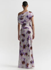 Woman wearing a one-shoulder floral dress on a white background