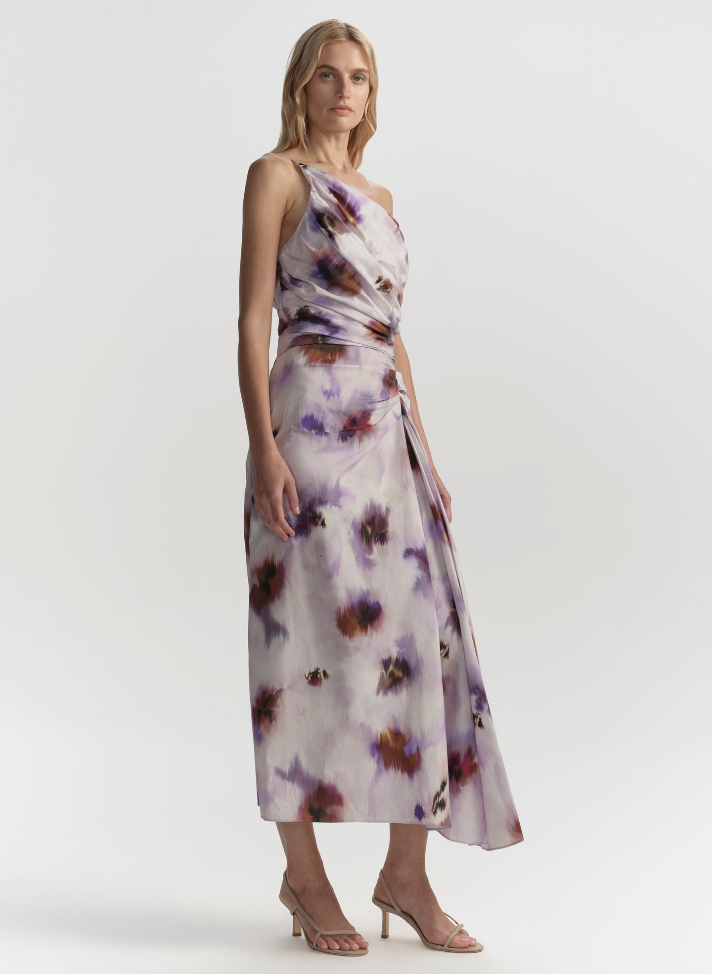 Woman wearing a floral one-shoulder dress on a white background