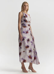 Woman wearing a floral one-shoulder dress on a white background