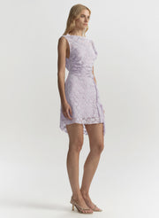 Woman wearing a light purple lace dress on a white background