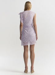 Woman wearing a light purple lace dress on a white background