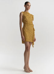 Woman wearing a mustard yellow lace dress on a white background