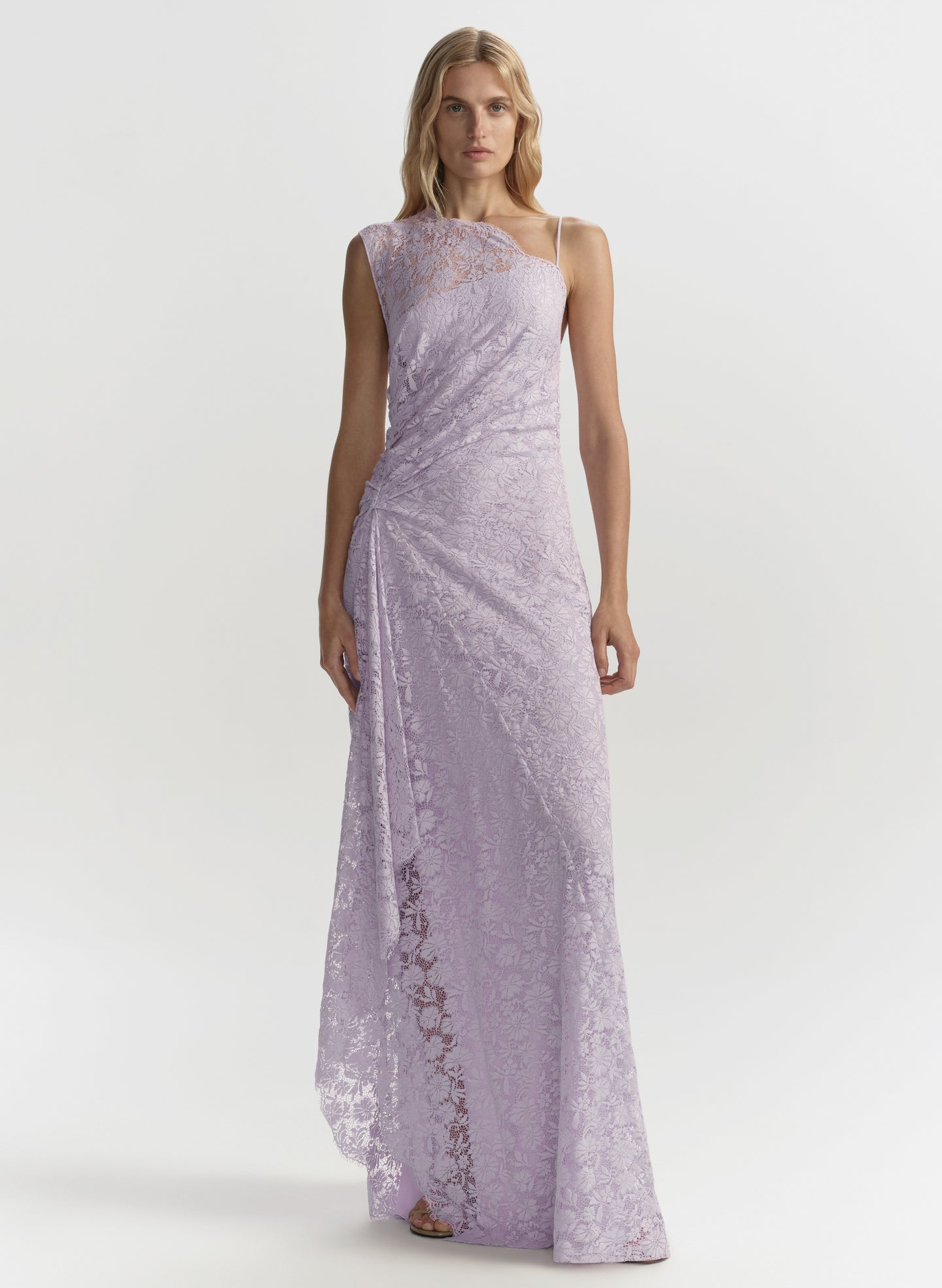 Woman wearing a long, light purple lace dress on a white background