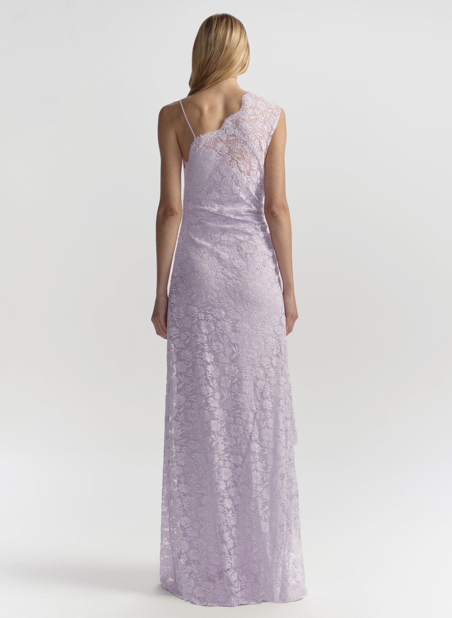 Woman wearing a long, light purple lace dress on a white background