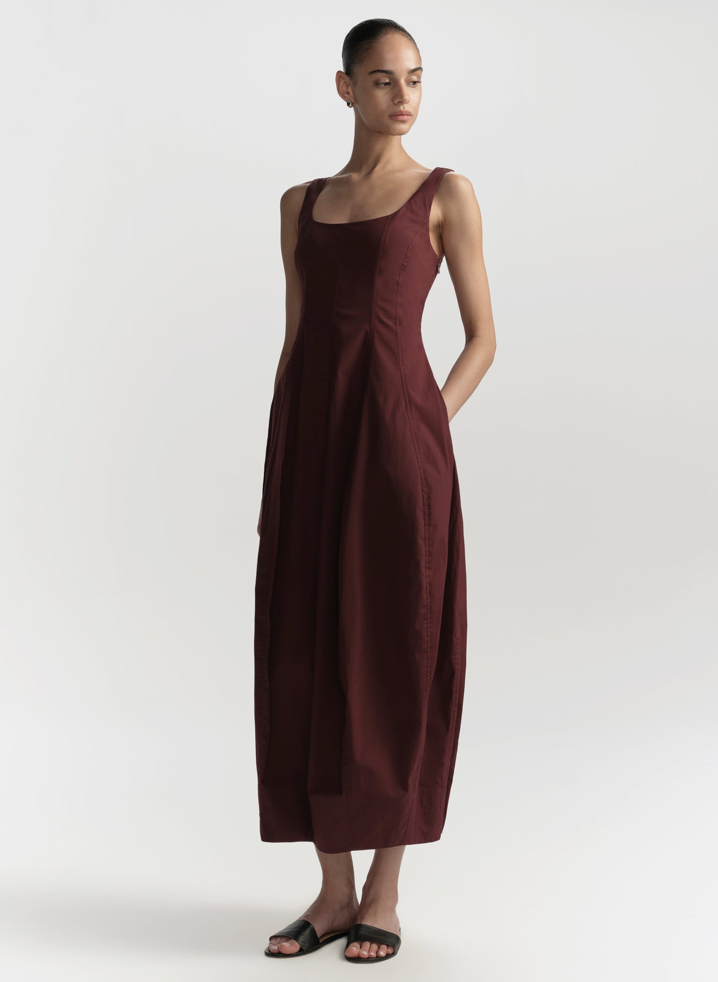 Woman wearing a burgundy dress on a white background