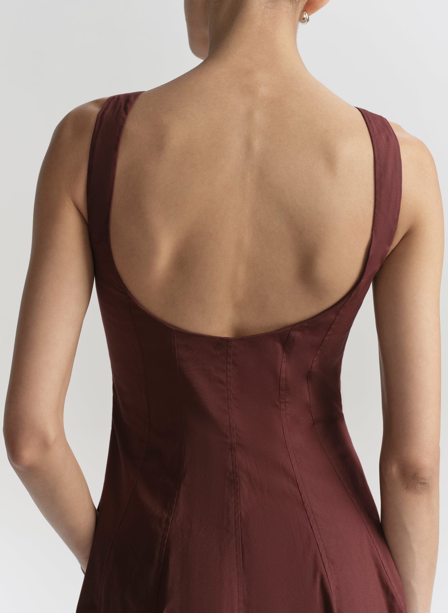 Brown dress with open back on a plain background