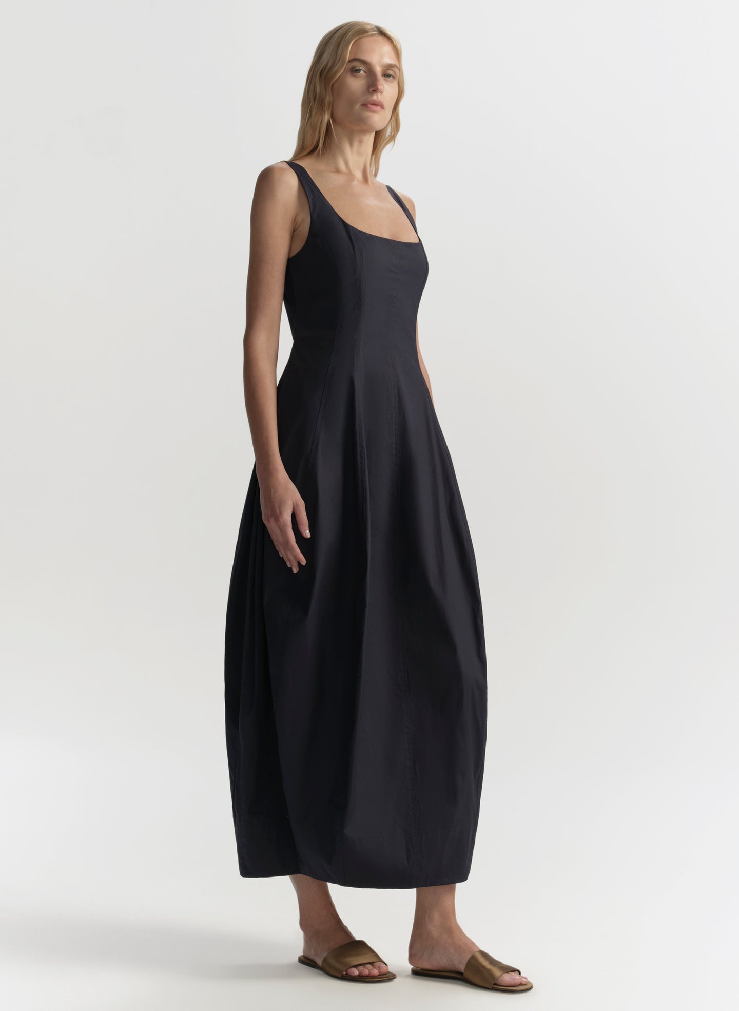 Woman wearing a blue sleeveless dress on a white background