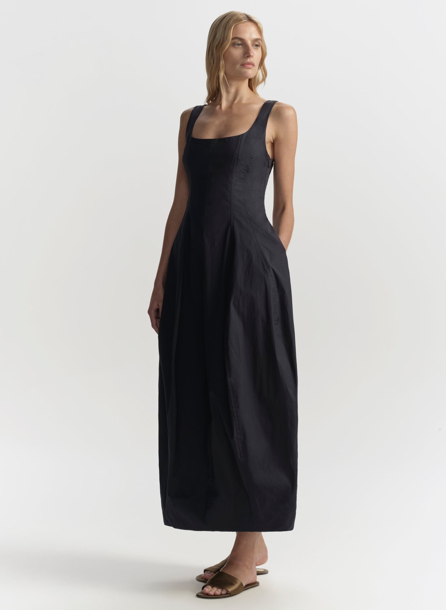 Woman wearing a blue sleeveless dress on a white background