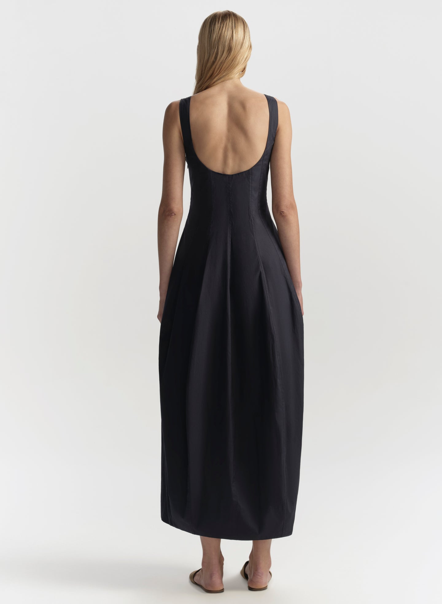 Blue sleeveless dress with open back worn by a model on a white background