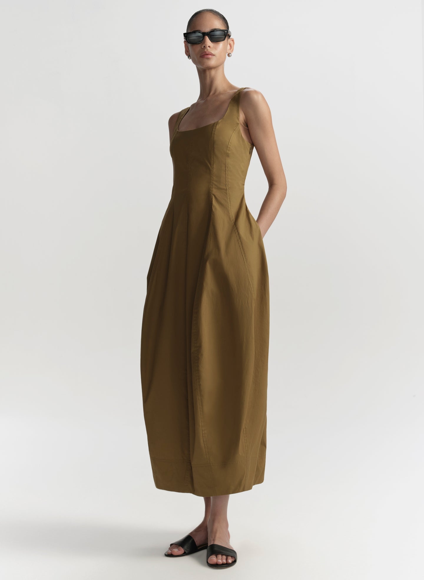 Woman wearing a long hazel dress on a white background