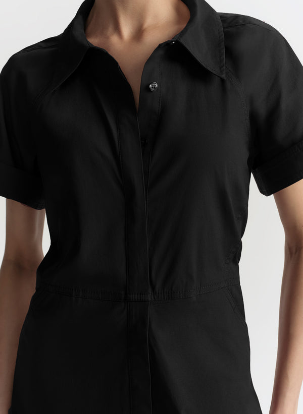 Black short-sleeve shirt worn by a person on a white background