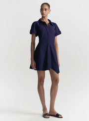 Woman wearing a navy blue dress on a white background
