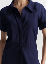 Navy blue short-sleeve shirt worn by a person on a white background