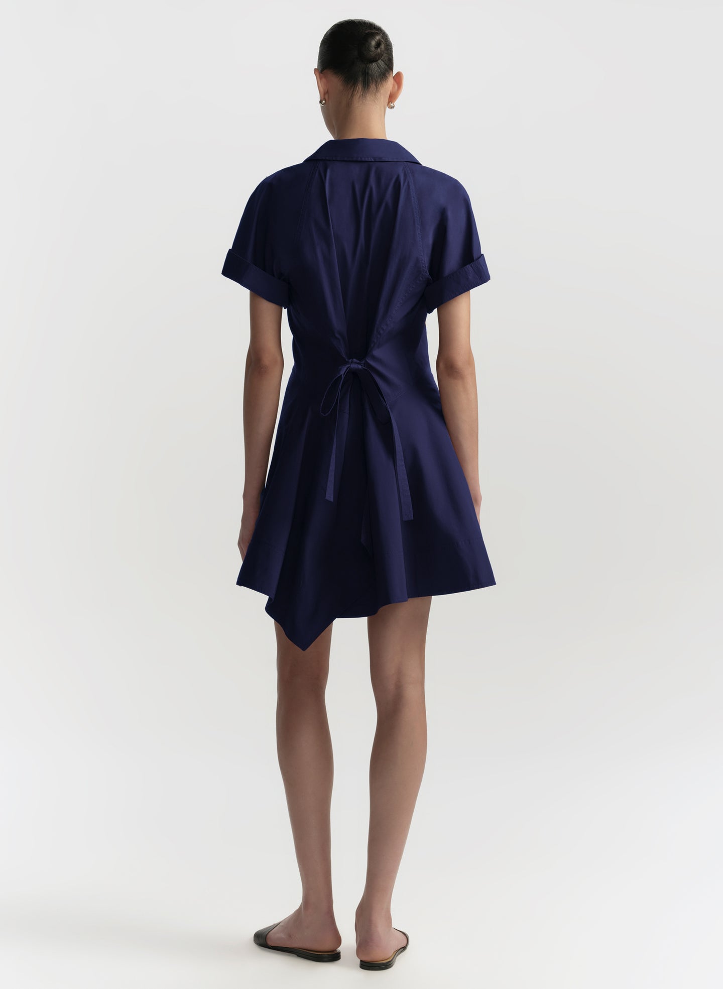 Navy blue dress with a tie waist on a white background