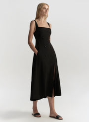 Woman wearing a black dress with a square neckline on a white background