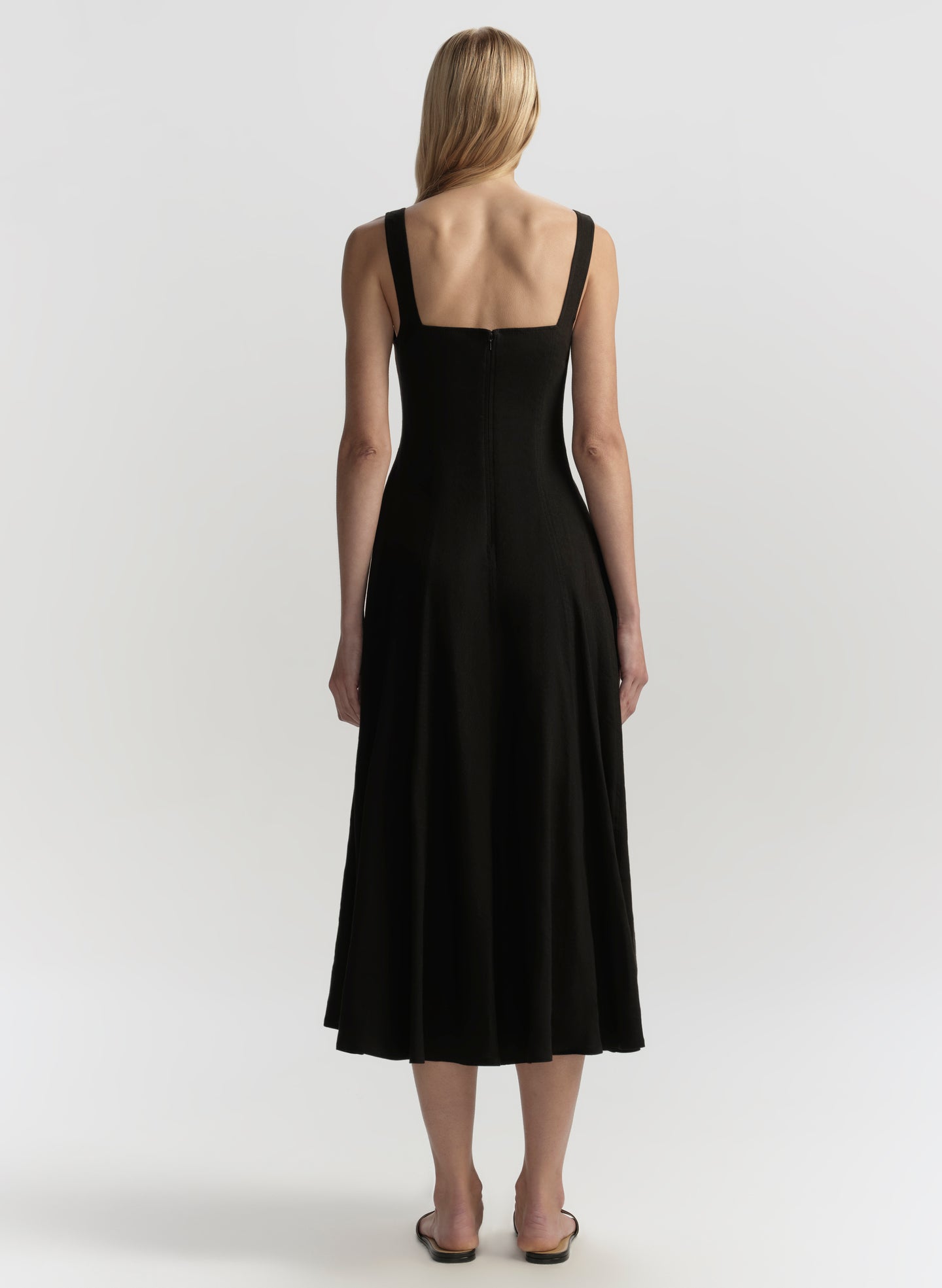 Woman wearing a black dress against a white background