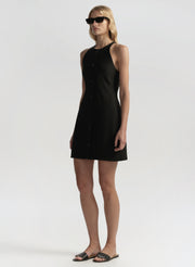 Woman wearing a black sleeveless dress on a white background