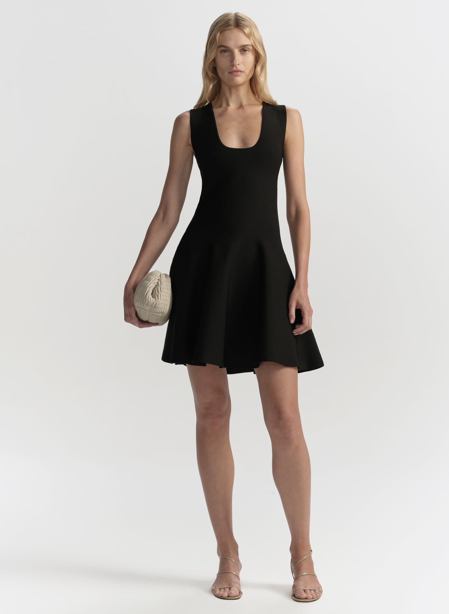 Woman wearing a black sleeveless dress on a white background