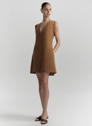 Woman wearing a brown dress on a white background