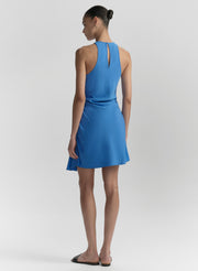 Woman wearing a blue dress on a light gray background