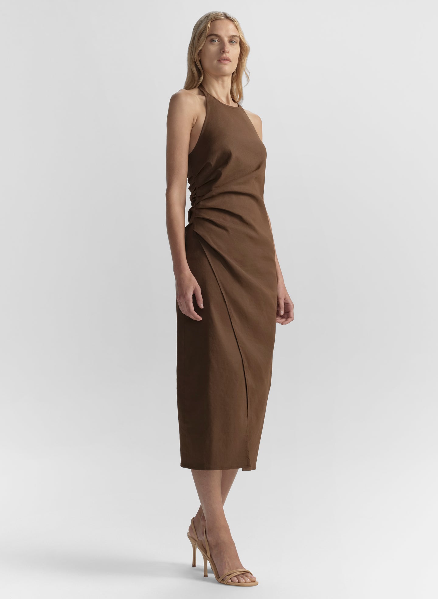 Woman wearing a brown dress against a white background