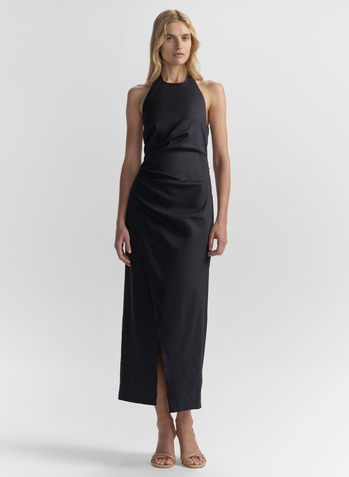 Woman wearing a blue halter neck dress on a white background