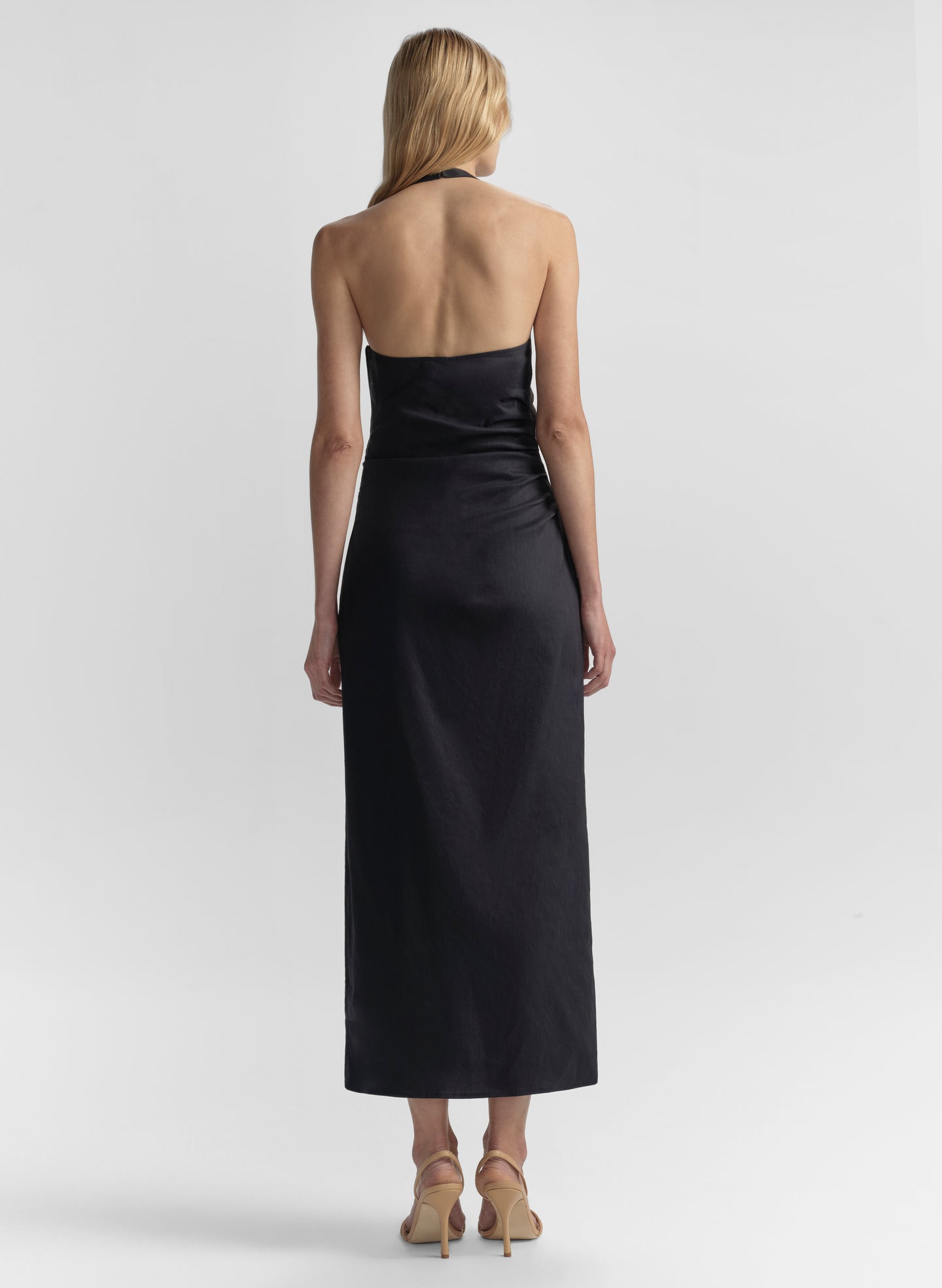 Woman wearing a blue halter neck dress on a white background