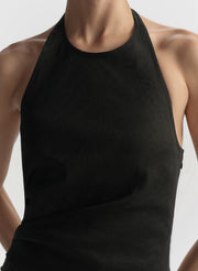 Black halter top worn by a person on a plain background