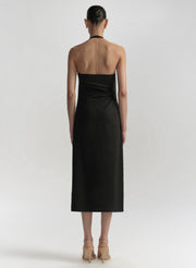 Woman wearing a black halter neck dress on a white background