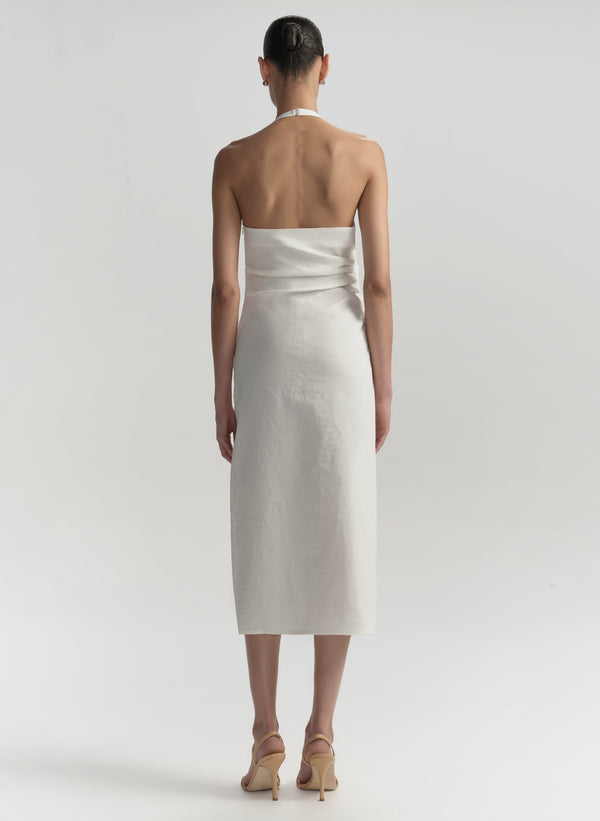Woman wearing a white strapless dress on a plain background